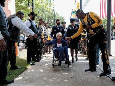 <p>Six Triple Eight veteran Romay Johnson Davis gets handshakes and fist bumps from members of the Buffalo Soldiers Motorcycle Club in Montgomery, Alabama, in July 2022.</p>